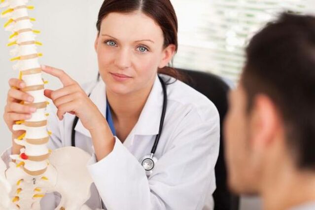 lékař demonstruje cervikální osteochondrózu na maketě